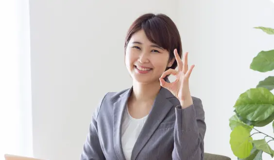 ノートPC前でOKサインをする女性のイメージ